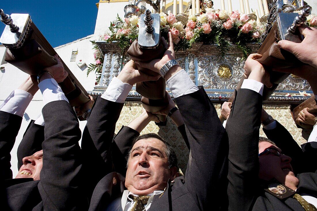 Men lift a heavy throne carrying the Virgin of Carmen during an Easter Holy Week procession in Prado del Rey village, Cadiz province, Andalusia, Spain.