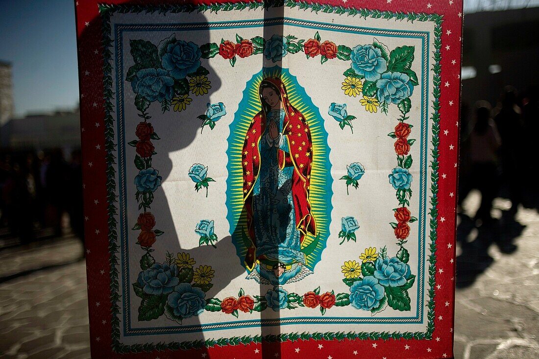 A woman´s silhouette is seen as she holds a banner with the image of the Our Lady of Guadalupe in Mexico City, December 10, 2010  Hundreds of thousands of Mexican pilgrims converged on the Basilica, bringing images to be blessed, as processions filled the