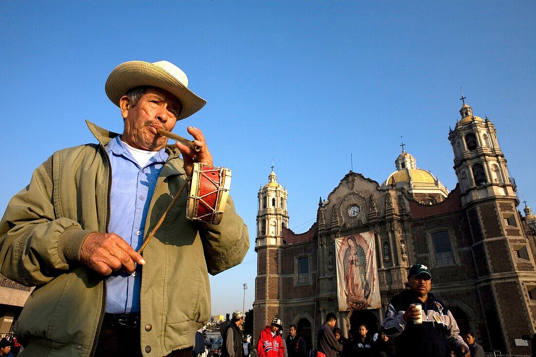 A musician plays a flute and a drum outside the Our Lady of Guadalupe Basilica in Mexico City, December 11, 2007  Millions of Mexican pilgrims converged on the Basilica, bringing images to be blessed, as processions filled the streets for the feast day of