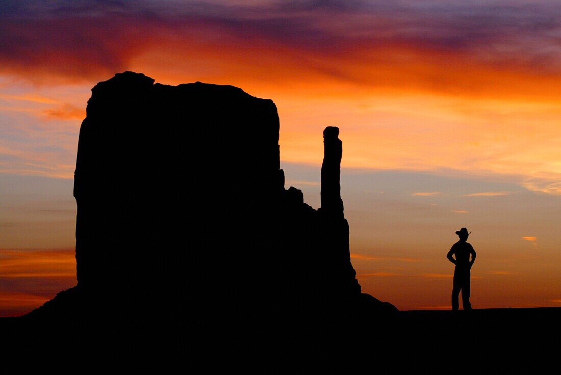 A Cowboy watches the sunset over the Mittens in Monument Valley on the southern border of Utah with northern Arizona  The valley lies within the range of the Navajo Nation Reservation  The Navajo name for the valley is Tsé Bii´ Ndzisgaii - Valley of the R