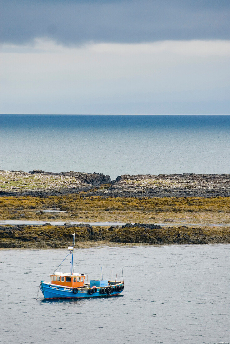 A harbour sea wall on the Isle of Skye, with a small traditional fishing boat moored. View  out to the Minch., Fishing boat off Isle of Skye looking out to the Minch