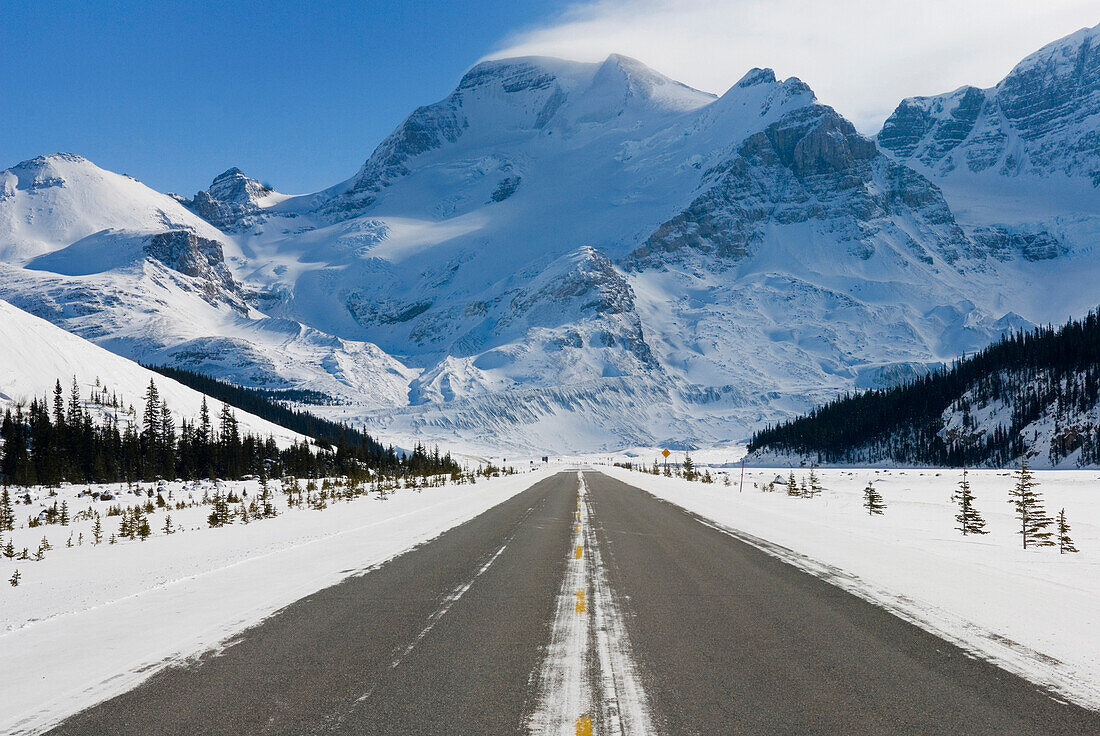 Icefields Parkway in winter. The scenic driving route. Roadway. Mount Athabasca in the distance, The Canadian Rockies. Jasper National Park, Alberta in Canada. Snow on the ground., Jasper National Park Alberta Canada