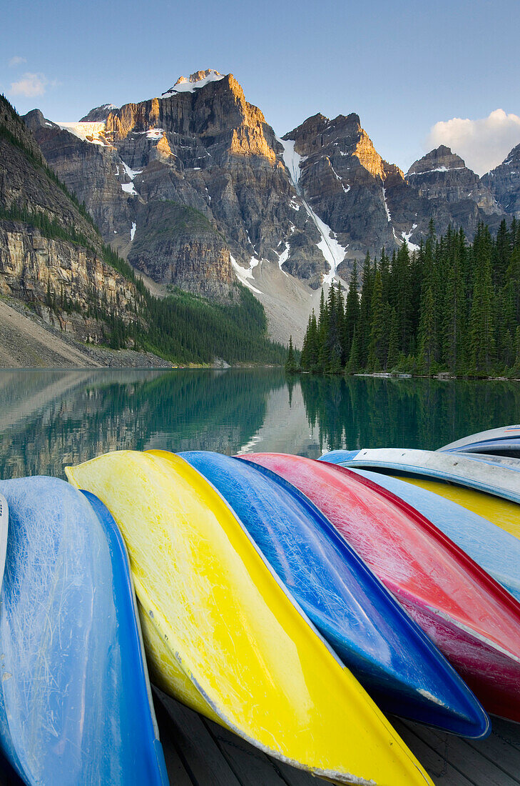 Colorful canoes on dock of Moraine Lake, in Banff National Park. The Canadian Rockies landscape, Mountain peaks. Flat calm water. Kayaks., Moraine Lake, Banff National Park Alberta Canada