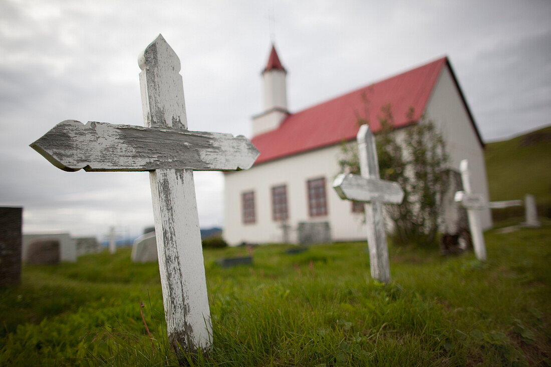 A traditional Christian church and a graveyard., Icelandic church in a remote setting