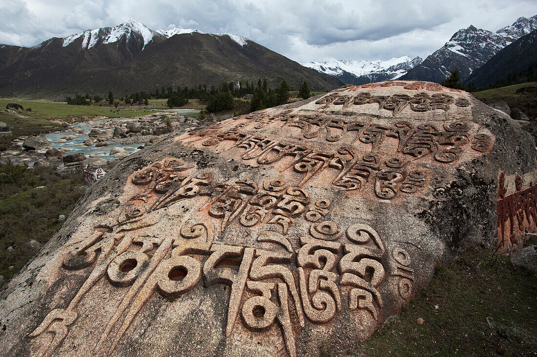 A giant Mani rock. Inscribed, inscriptions. Religious prayer stones. Yihun Lhatso, a holy alpine lake, om the valley between Manigango and Dege., Sichuan Tibet