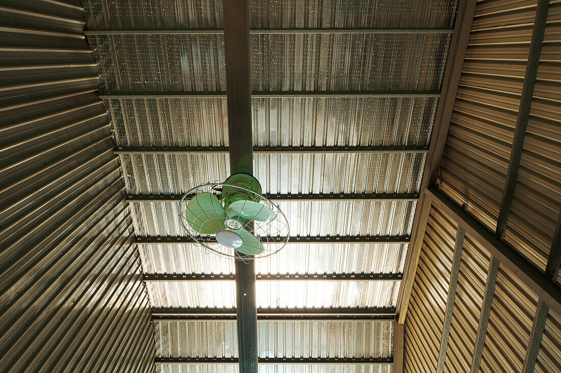 Simple iron roof of warehouse with a electric fan for ventilating, Taiwan, Asia.