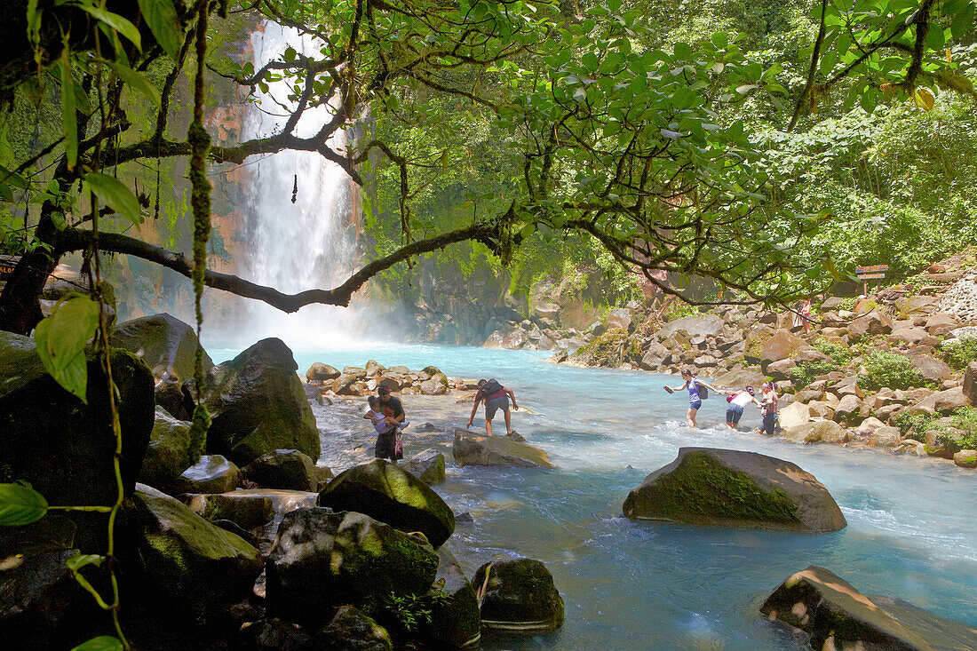 People in front of waterfall Rio Celeste at Tenorio National Park, Costa Rica, Central America, America