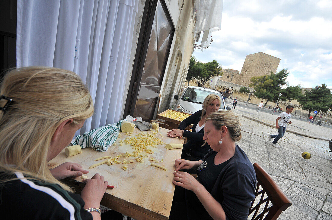 Frauen bei der Herstellung von Orecchiette in der Altstadt von Bari, Apulien, Italien