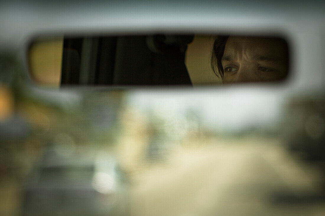 Man's Eyes Reflected in Car Mirror