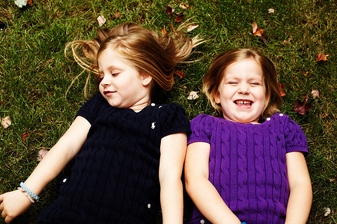 Two Young Girls Laying on Grass