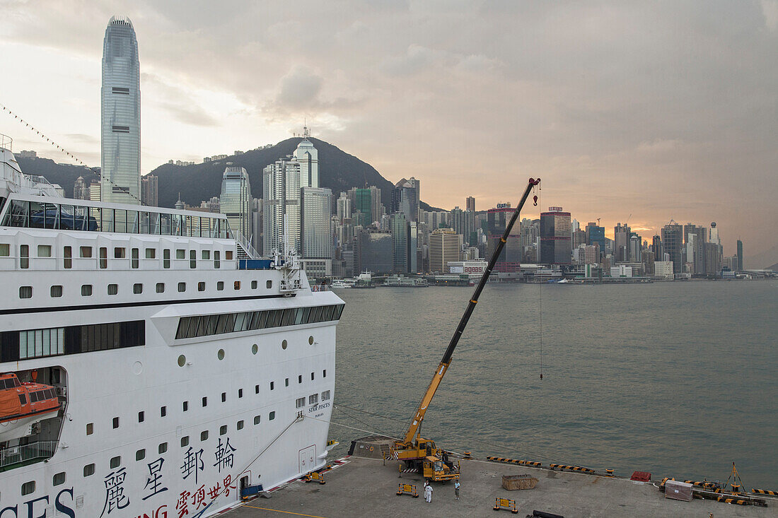 Kreuzfahrtschiff am Pier Tsimshatsui vor der Silhouette von Hong Kong Island, Hongkong, China, Asien
