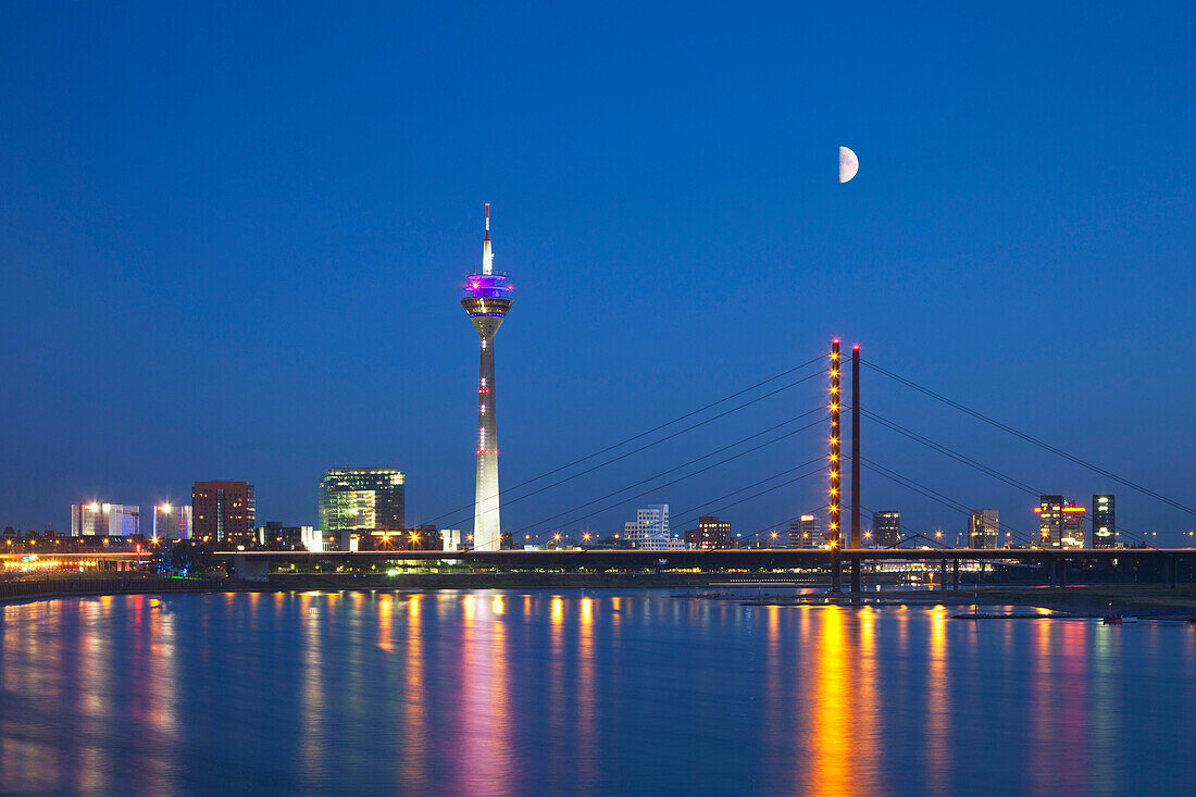 View over the Rhine river to Rhine tower and media harbour at night, Duesseldorf, North Rhine-Westphalia, Germany, Europe