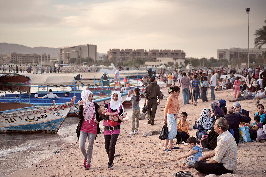 Junge Jordanierin mit Baby am überfüllten Stadtstrand, Golf von Akaba, Rotes Meer, Jordanien, Naher Osten, Asien