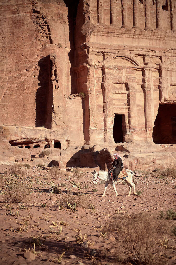 Beduinen Frau reitet auf Esel an Königsgräber vorbei, Petra, UNESCO Weltkulturerbe, Wadi Musa, Jordanien, Naher Osten, Asien