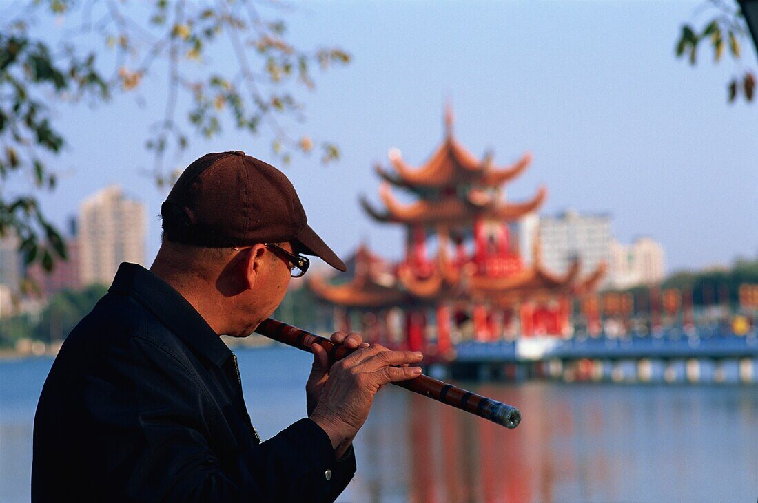 Taiwan,Kaohsiung,Man Playing Flute at Lotus Lake