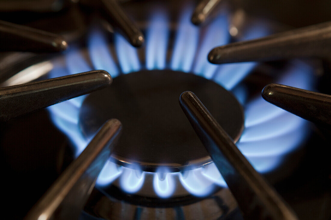 Thousand Oaks, California, USA. Domestic kitchen interior, Close up of the gas hob with the burner lit. Power heat and energy. Blue flames., Gas Burner on Stove