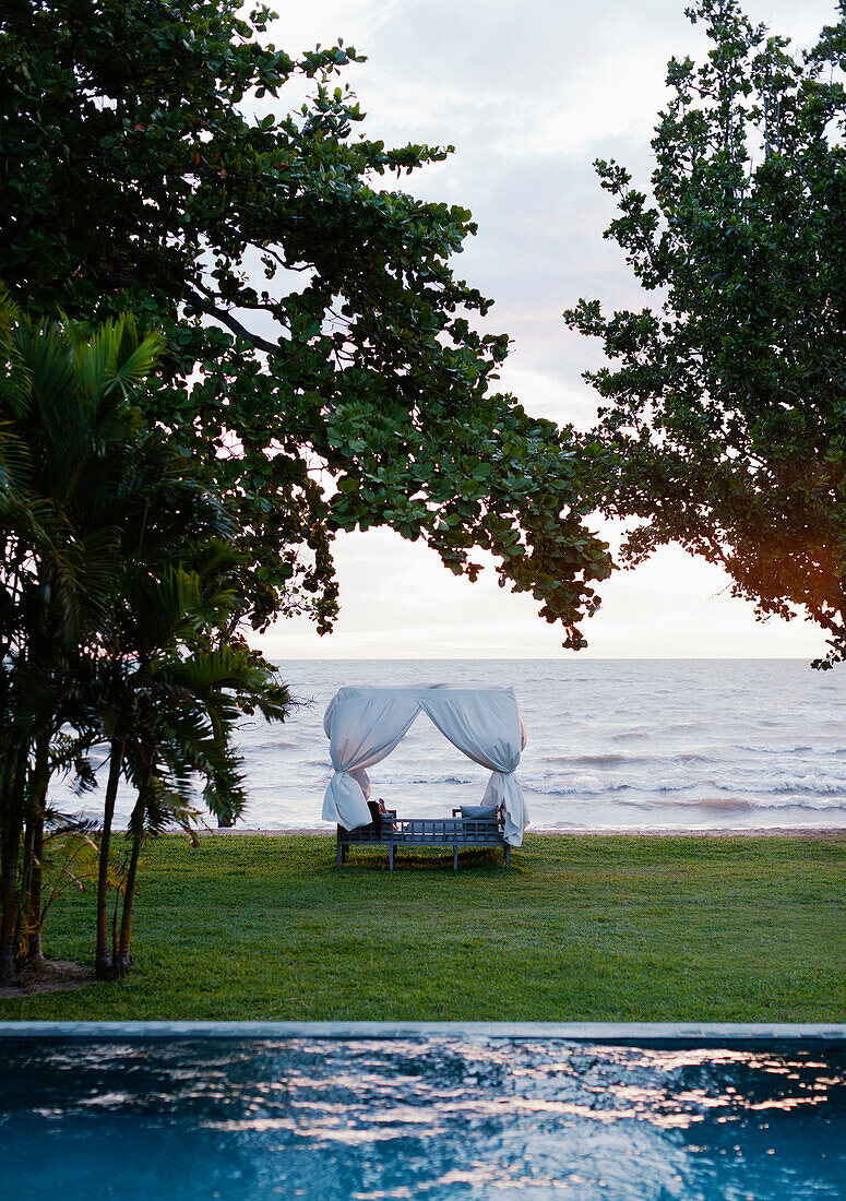 A view of the infinity pool and Gulf of Thailand at Knai Bang Chatt Hotel., Kep, Cambodia/Outdoor Canopy Bed