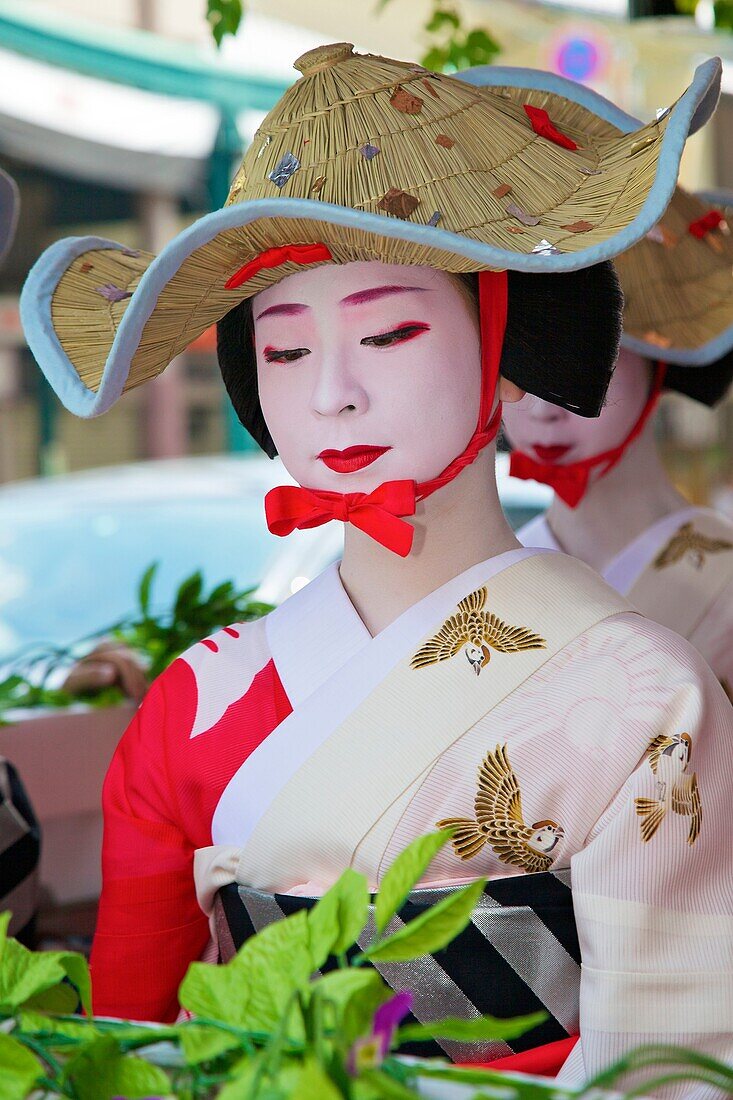 A geisha in a summer kimono wearing a strange hat