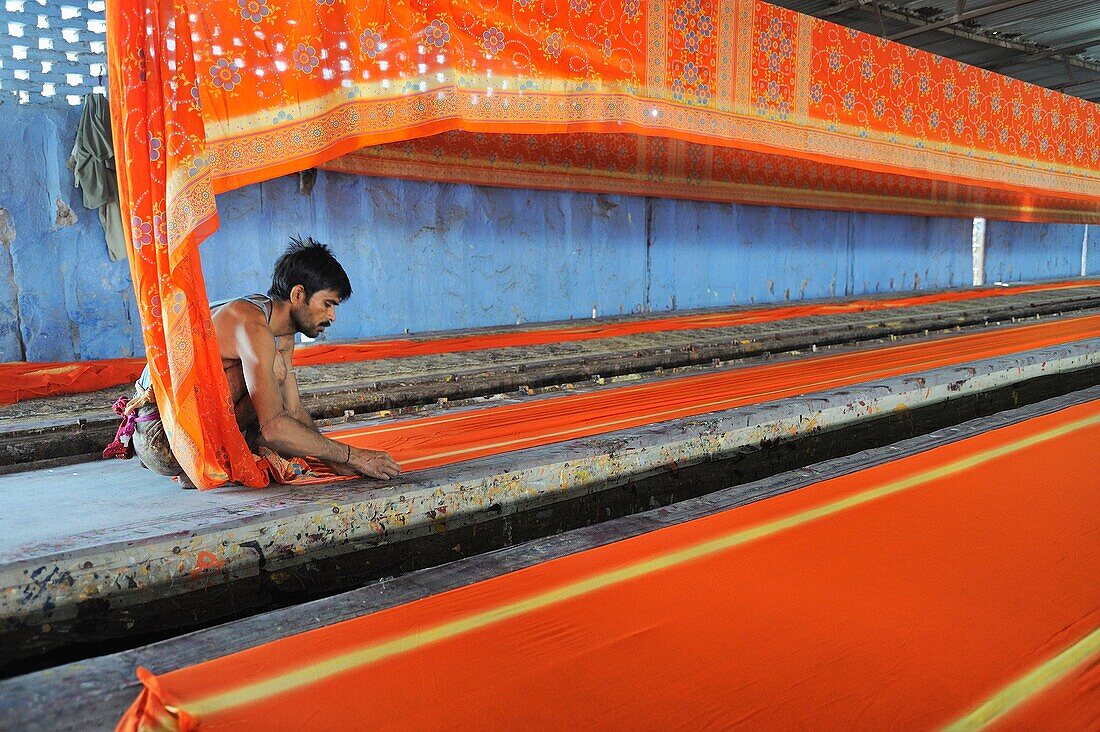 India, Rajasthan, Saree factory, Worker laying 150 m long sarees before printing