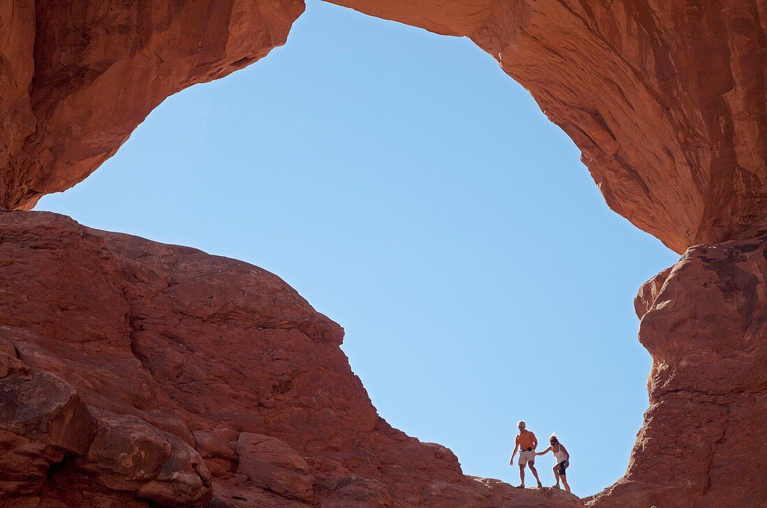 Moab, Utah - A couple in one of the arches at Double Arch in Arches National Park