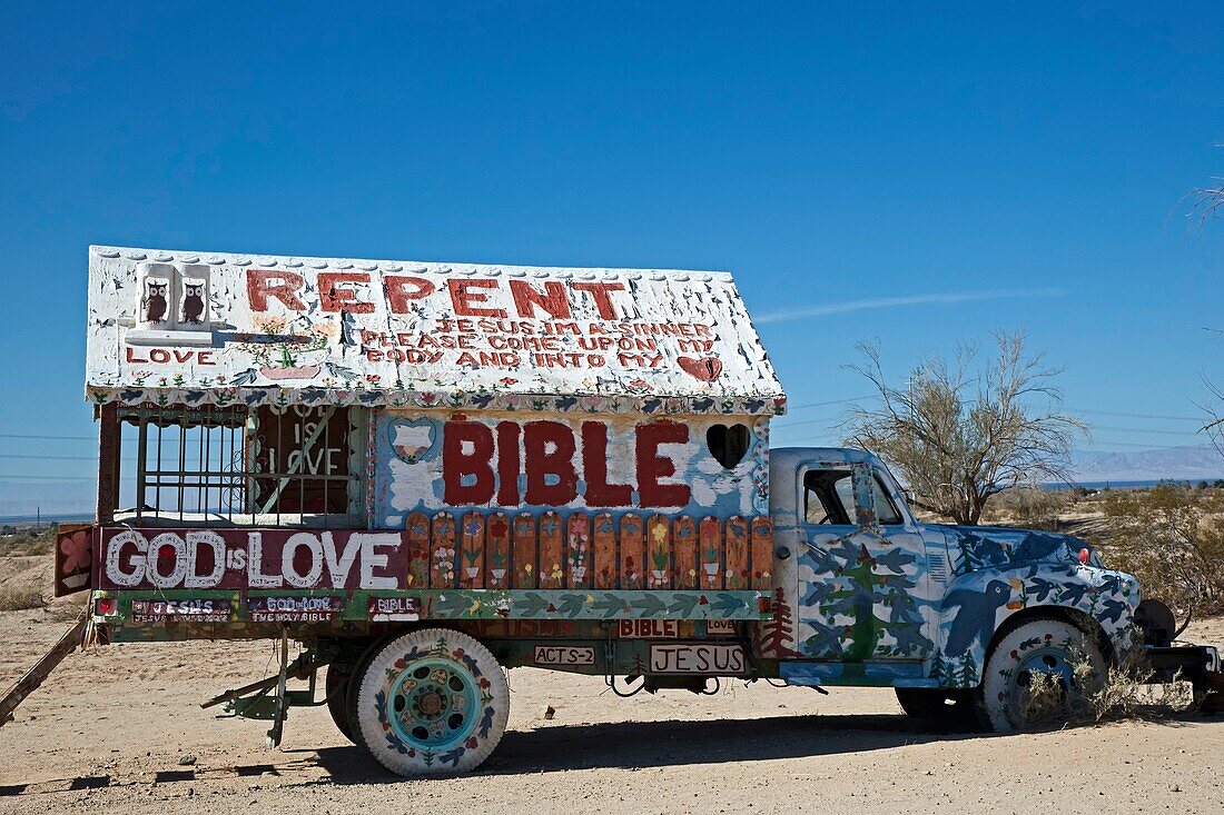 Niland, California - Salvation Mountain, a desert hillside covered with religious messages, created by Leonard Knight  An old truck decorated with religious slogans is on the property