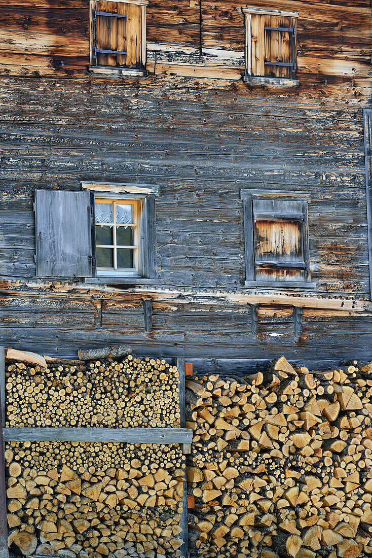 Holz ist vor altem Bauernhaus aufgeschichtet, Walserweg, Strassberg, Arosa, Graubünden, Schweiz