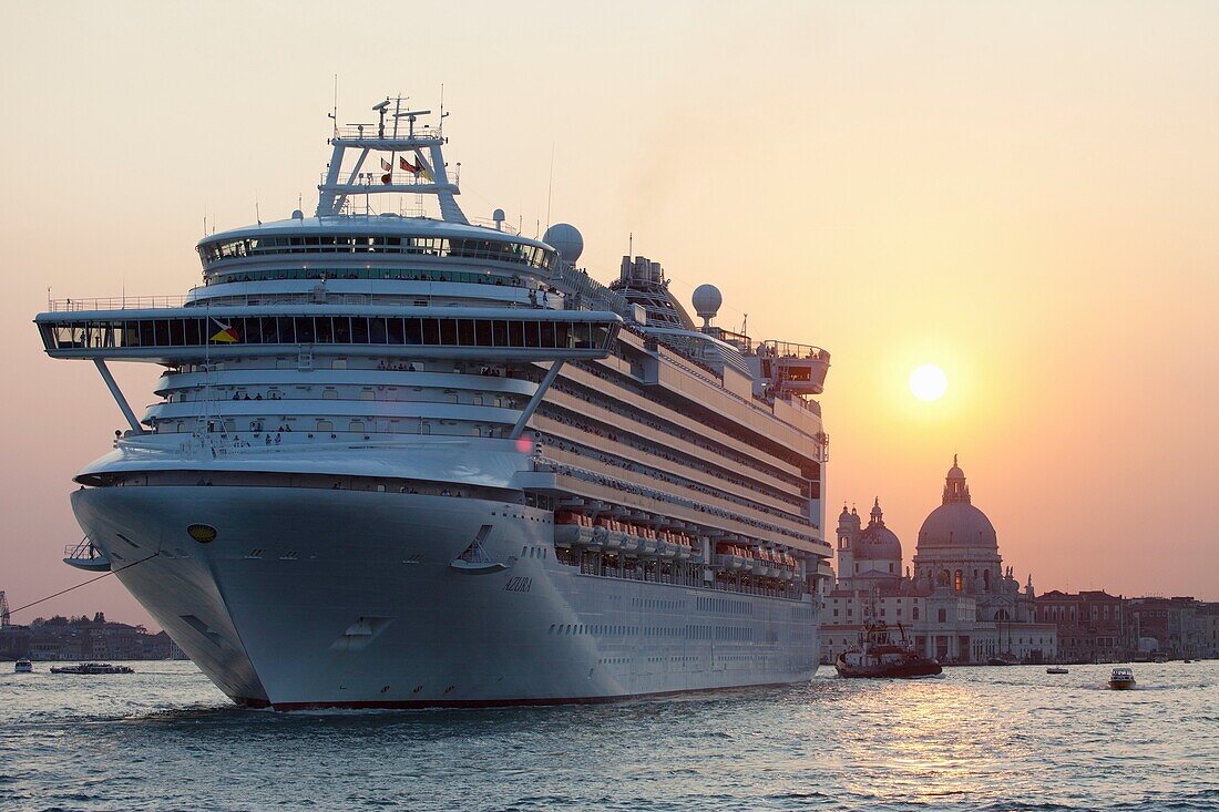 Kreuzfahrtschiff verlässt Venedig bei Sonnenuntergang mit Santa Maria della Salute im Hintergrund