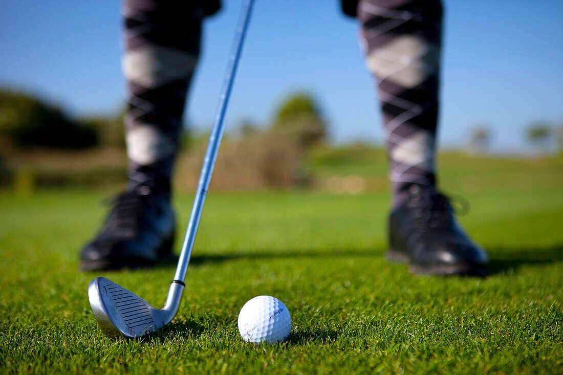 Detail eines Golfspielers mit einem siebener Eisen auf einem Fairway