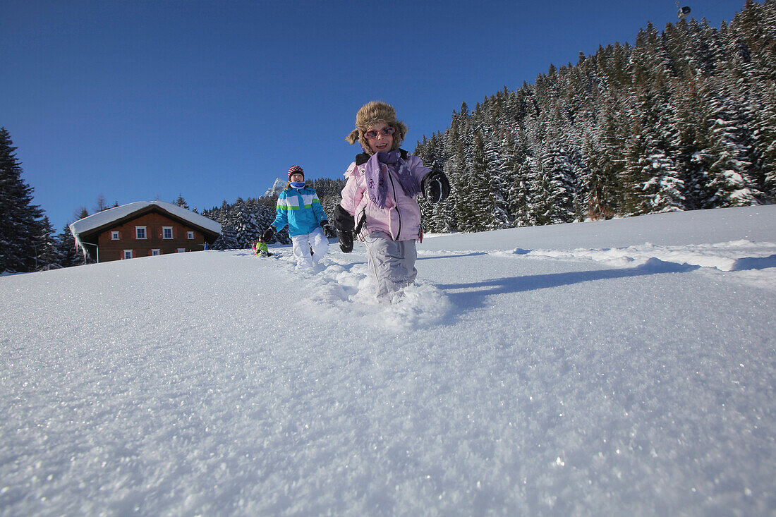 Zwei Kinder rennen im Schnee, Gargellen, Montafon, Vorarlberg, Österreich