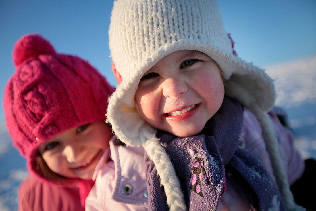 Two girls smiling at camera, Kammerloh, Muensing, Bavaria, Germany