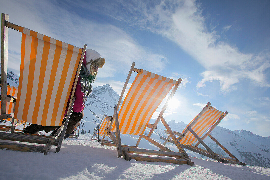 Woman relaxing in a deckchair in snow, Kuehtai, Tyrol, Austria