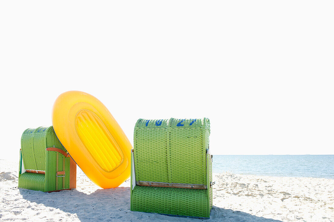 Green beachchairs and yellow rubber dinghy on the beach, Wyk, Foehr, North Frisian Islands, Schleswig-Holstein, Germany, Europe