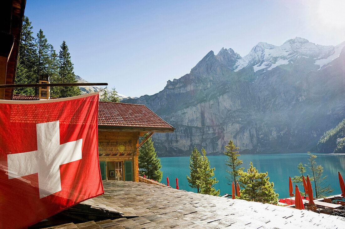 Swiss flag at lake Oeschinensee, Kandersteg, Bernese Oberland, Canton of Bern, Switzerland, Europe