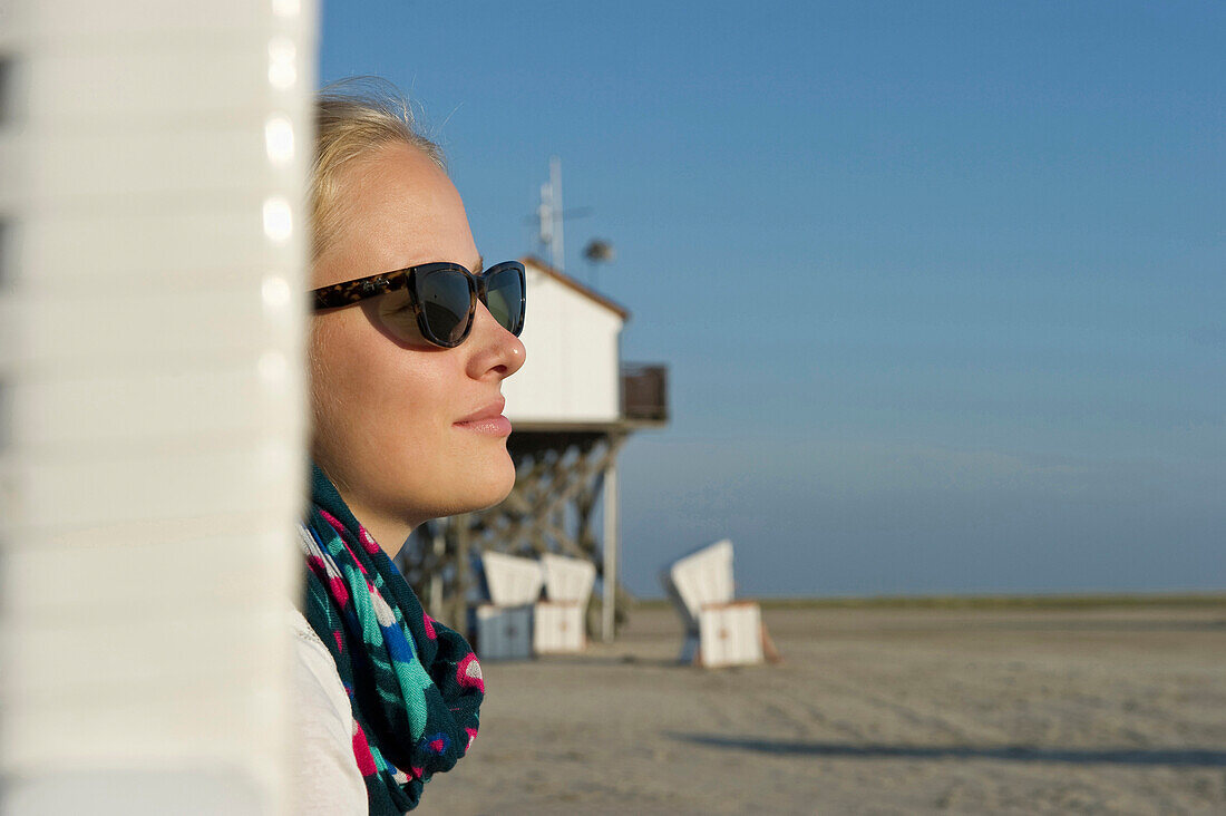 Junge Frau im Strandkorb am Strand von St Peter-Ording, Halbinsel Eiderstedt, Nationalpark Schleswig-Holsteinisches Wattenmeer, Nordfriesland, Schleswig-Holstein, Deutschland, Europa