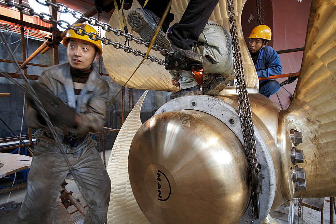 Chinesische Werftarbeiter installieren Flügel an Verstellpropeller, MAN Diesel liefert den Motor, die Schraubenwelle und den Propeller, Schiffsneubau im Trockendock, Ouhua Werft in Zhoushan, Zhejiang Provinz, China