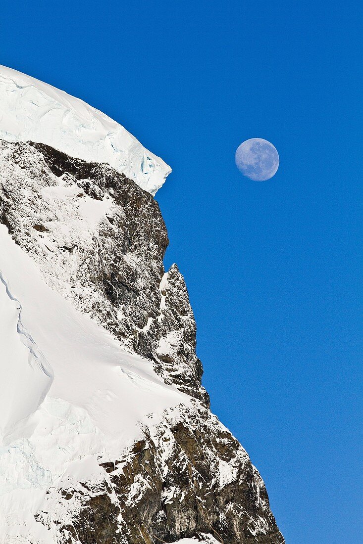 View of the moon rising over snow-covered mountains on the Antarctic Peninsula, Antarctica. View of the moon rising over snow-covered mountains on the Antarctic Peninsula, Antarctica MORE INFO Lindblad Expeditions pioneered non-scientific travel to Antarc