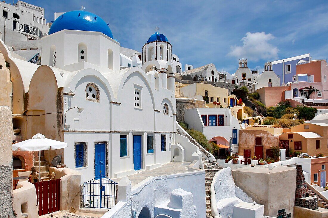Blue dome churches with blue doors and white siding in the village of Oia in Santorini, Greece