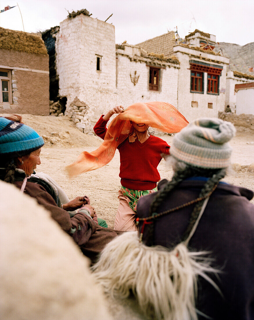 Girl banters with women in village Yangthang, Sham Trek west of Leh, Ladakh, Jammu and Kashmir, India
