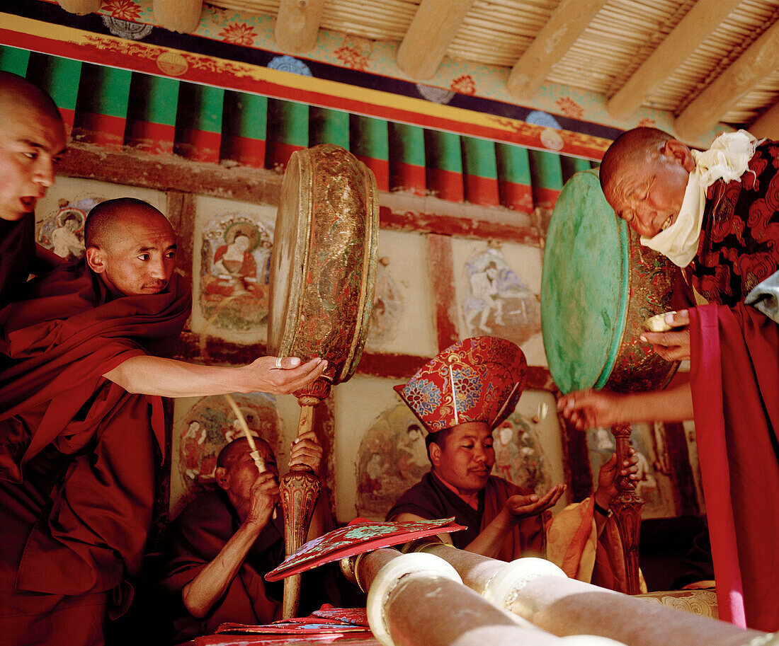 Mönche mit Trommeln und Blasinstrumenten empfangen gesegnetes Essen beim jährlichen Hemis Gonpa Festival im Kloster Hemis, südöstlich Leh, Ladakh, Jammu und Kashmir, Indien