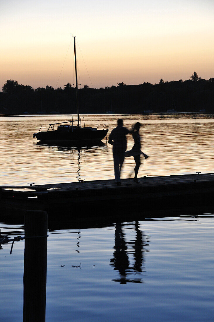 Paar tanzt auf einem Steg am Ammersee bei Sonnenuntergang, Herrsching, Oberbayern, Bayern, Deutschland, Europa