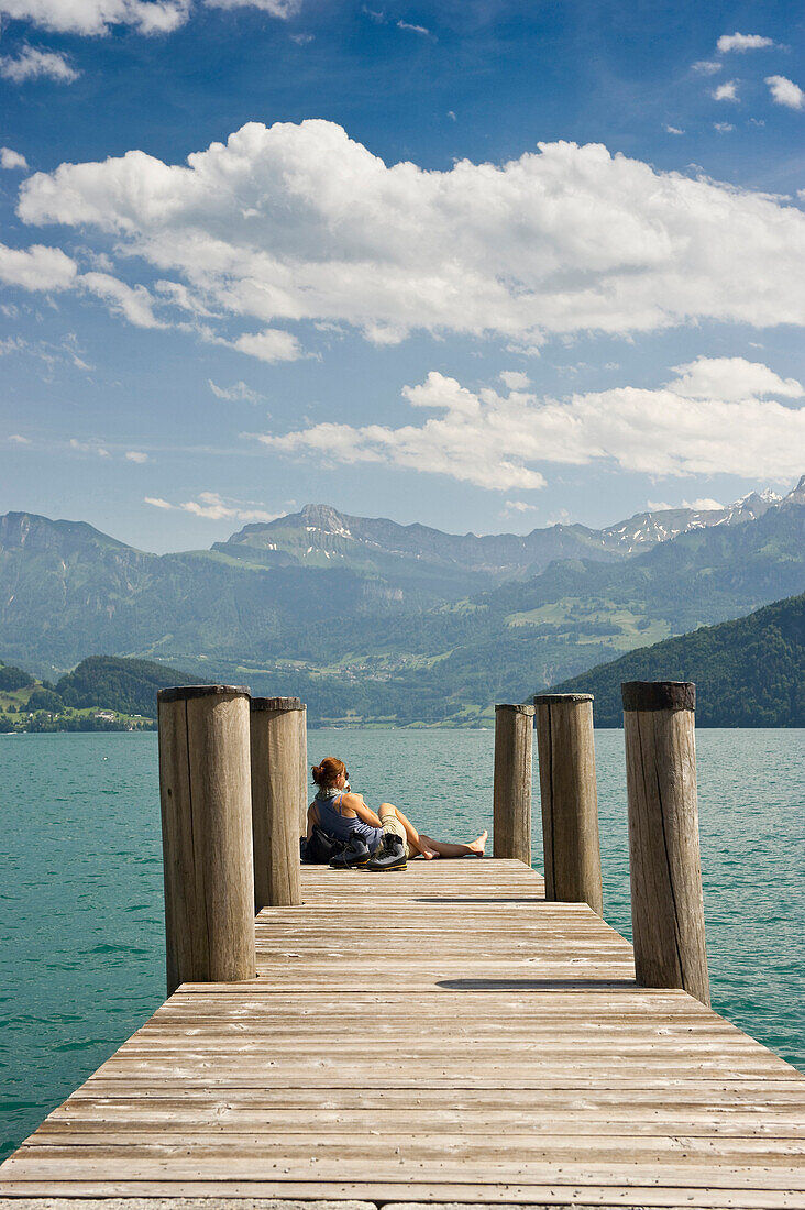 Female hiker sitting on a landing stage in Weggis, Lake Lucerne, canton Lucerne, Switzerland, Europe