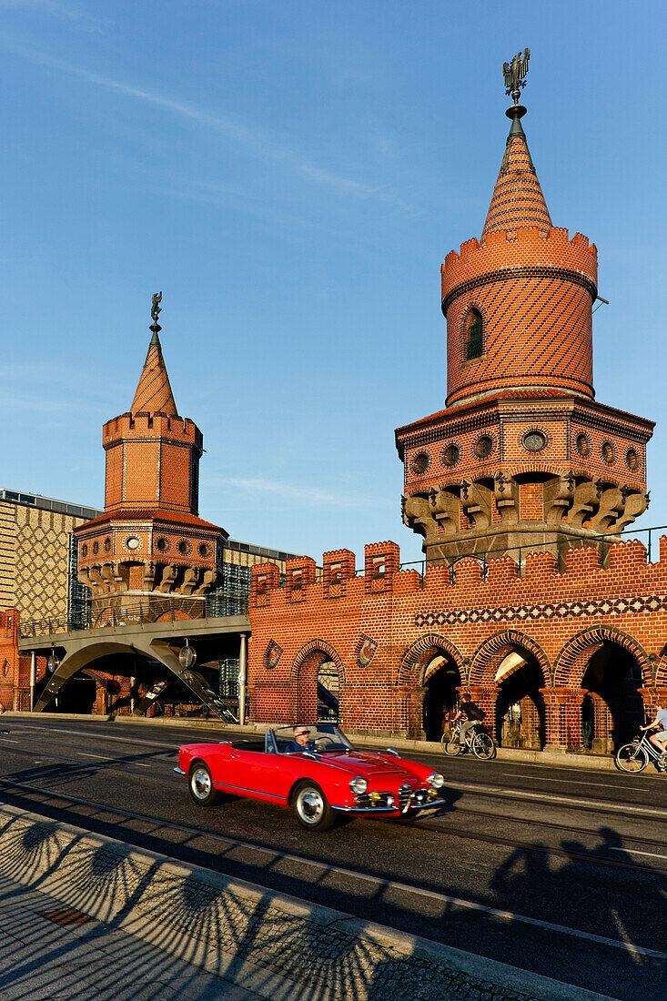 Red cabrio at the Oberbaum Bridge, Oberbaumbruecke over river Spree, architect Otto Stah, Kreuzberg, Berlin