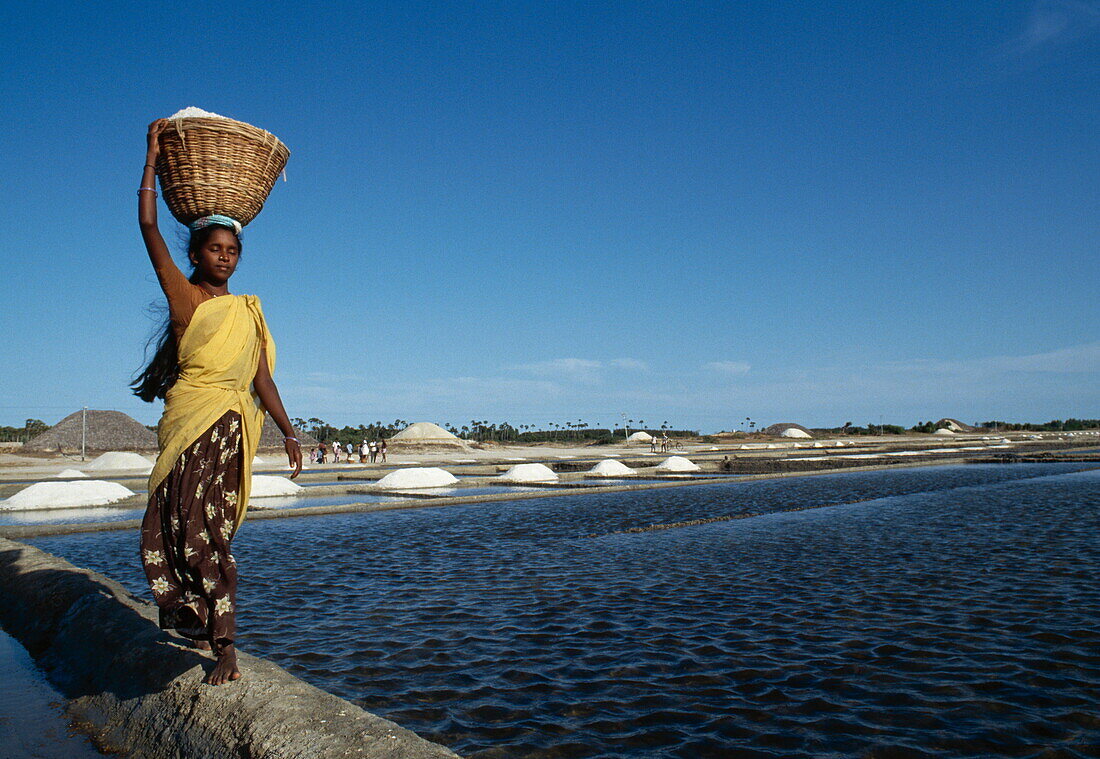 Frau trägt einen Korb mit Salz von den Salinen, Chennai, Tamil Nadu, Indien, Asien