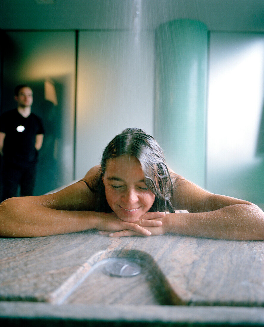 Woman enjouying a rain shower in a spa, Langenlois, Lower Austria, Austria