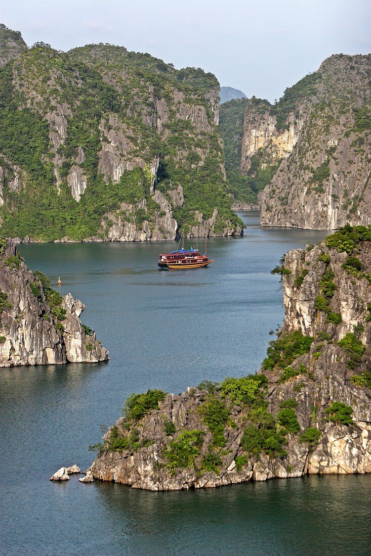 Cruising junk among rocky islands of Halong Bay Vietnam