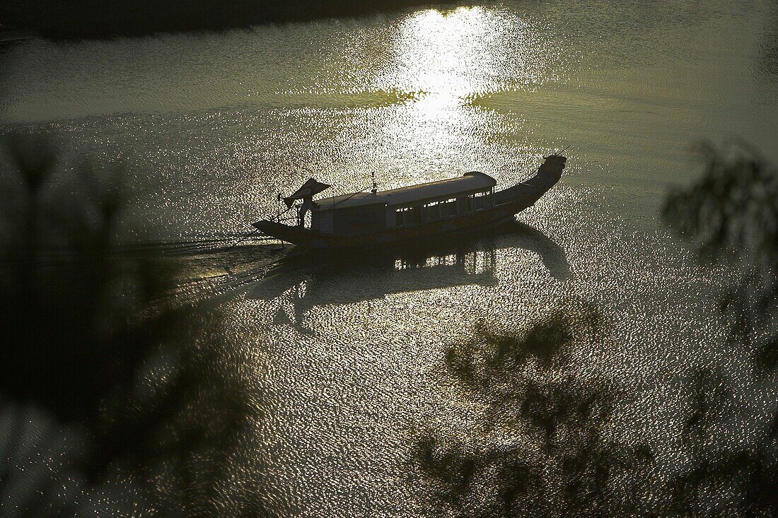 Traditional Vietnamese boat sails up Perfume River passed Vong Canh Hill near Hue central Vietnam