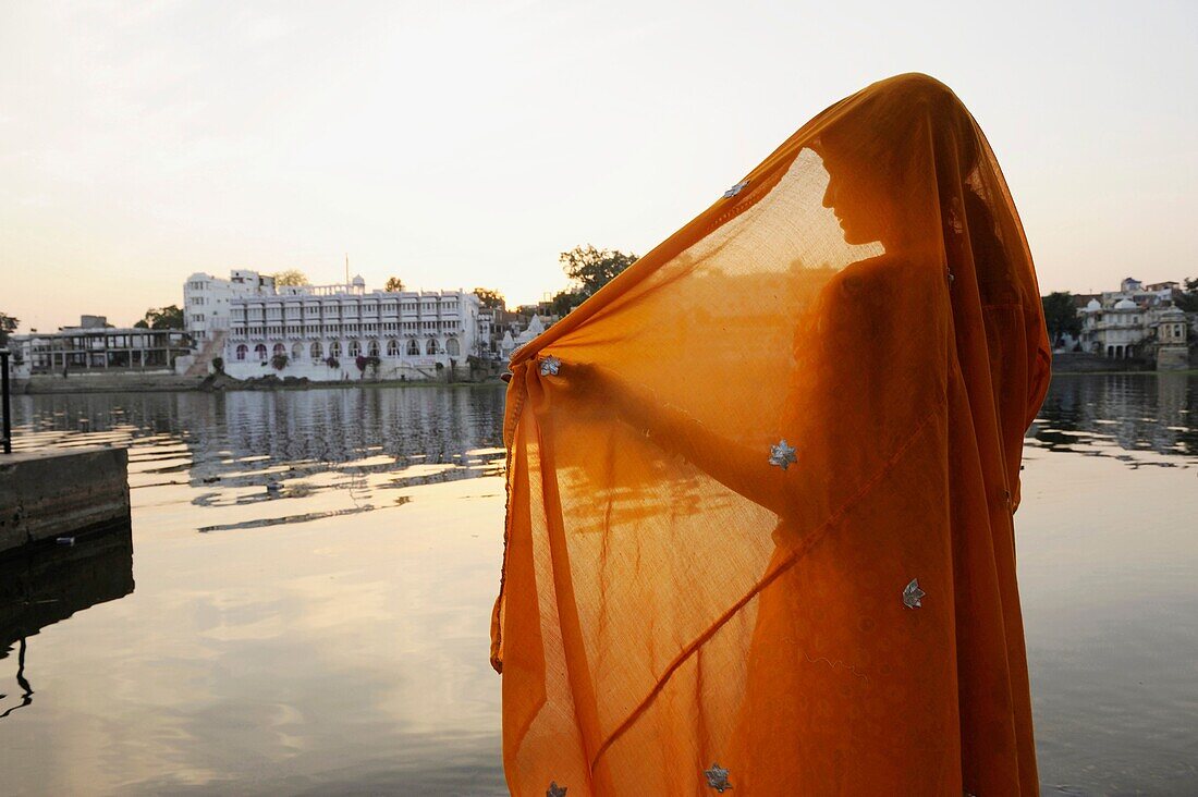 Asia,India,Rajasthan,Udaipur,woman wearing a sari in front of Pichola lake