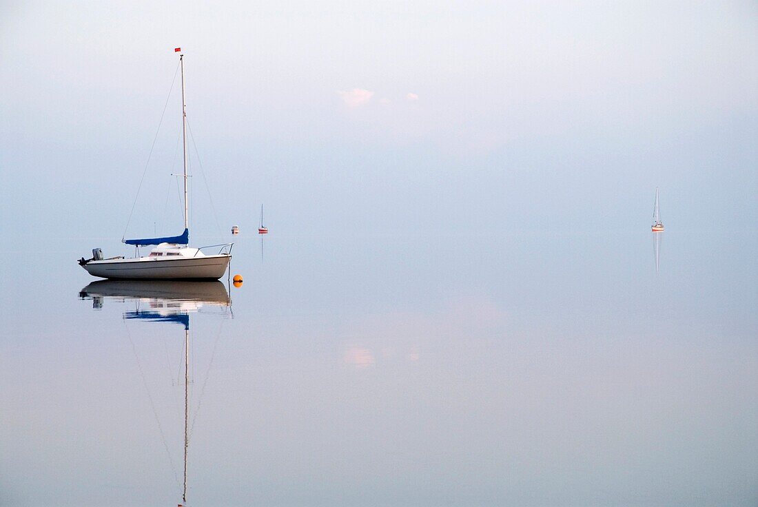 Reflections of sailboats in Wadden Sea, Juist, Germany