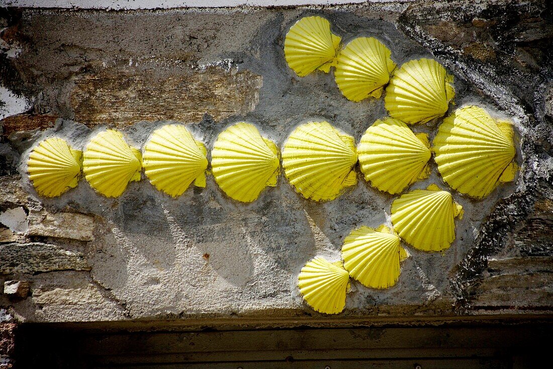 A yellow arrow made of scallop shells is displayed in a house to guide pilgrims in the French Way that leads to Santiago de Compostela, Spain. Hundred of thousands pilgrims walk every year to Santiago de Compostela using the French Way in the pilgrimage k