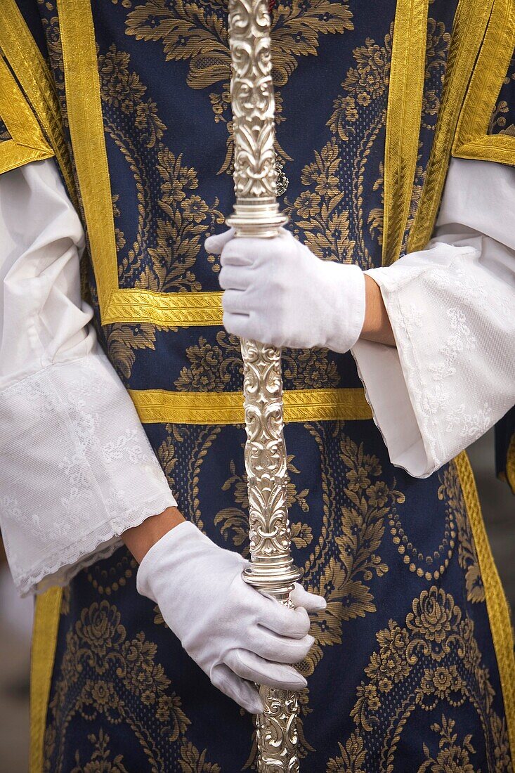 An acolyte holds a cross during an Easter Holy Week procession in Cordoba, Spain, April 18, 2011
